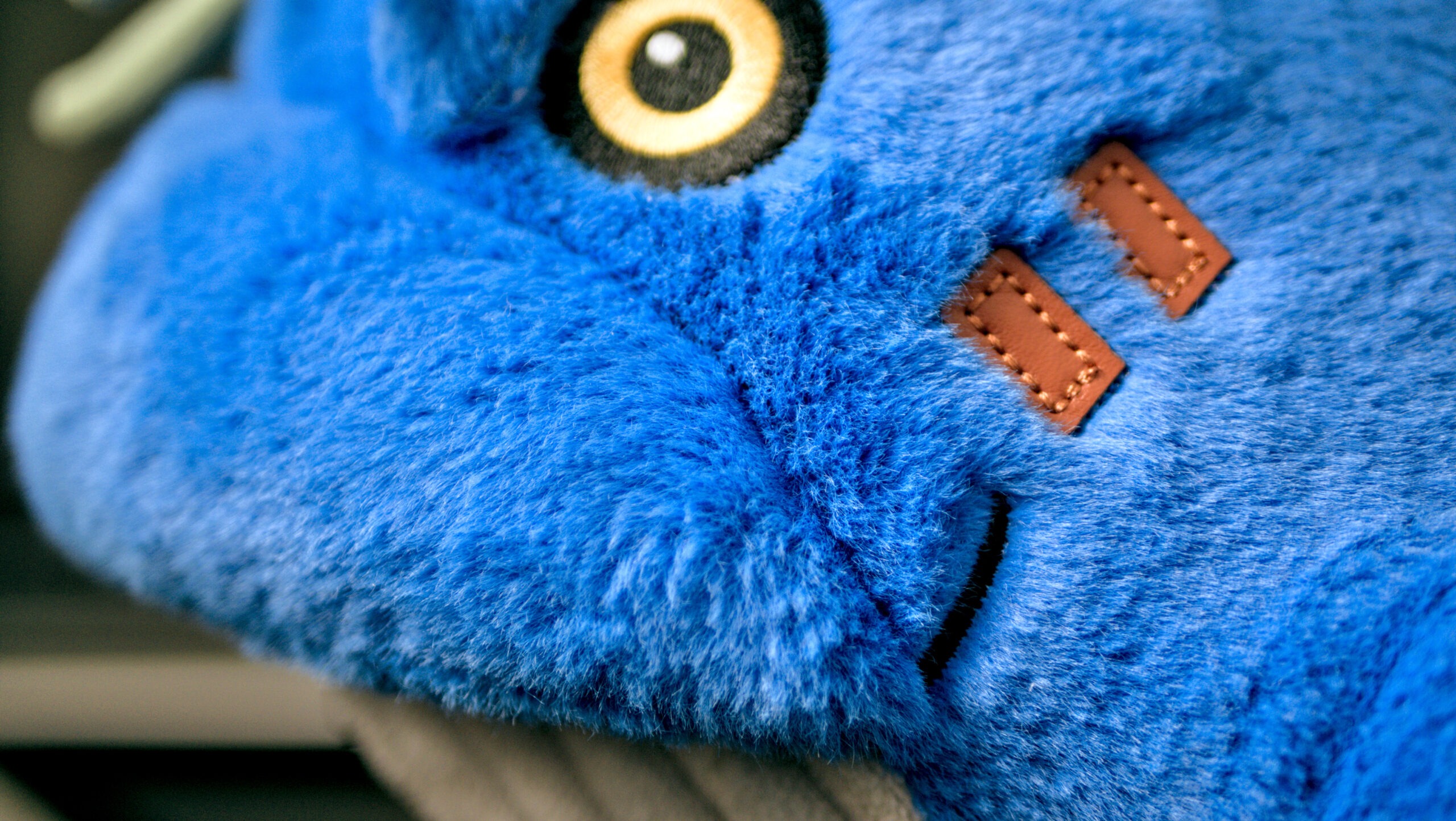 Close-up of Marlow designer toy showing premium faux rabbit fur, hand-stitched PU leather patch, and high-quality embroidery details.